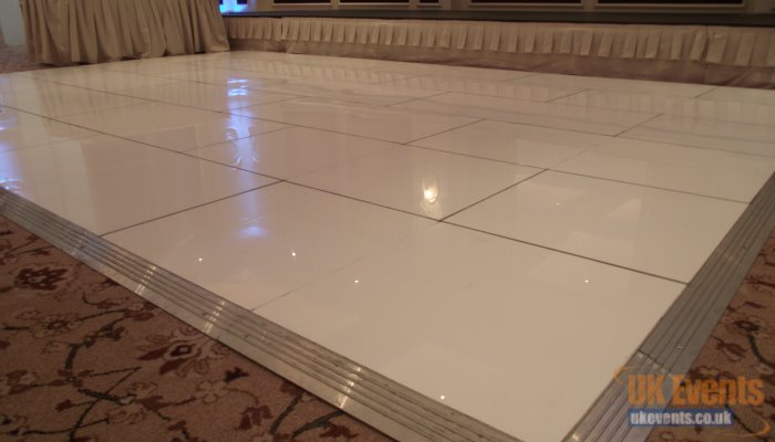 a plain white dance floor that was installed to a marquee